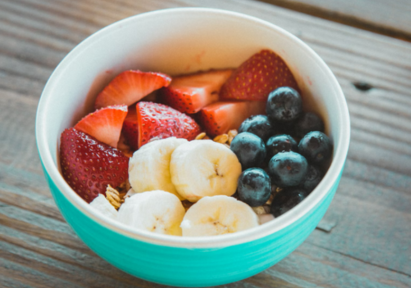 A simple bowl containing a variety of fruits.