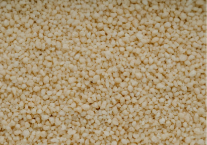 Close-up of uncooked couscous grains in a textured pile.