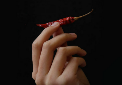 A woman holdidng onto a chilli.