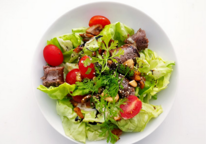 A plate of salad with a variety of vegetables.