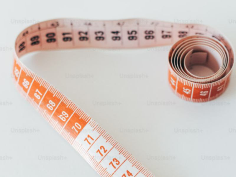 Close-up of a measuring tape, symbolizing progress and tracking measurements during a weight loss journey.