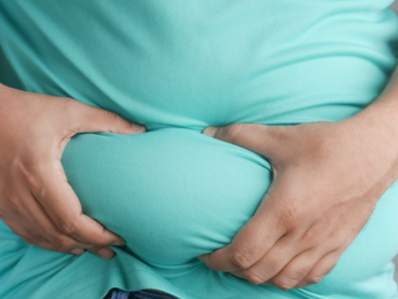 A guy holding onto his stomach wanting to start weight management.