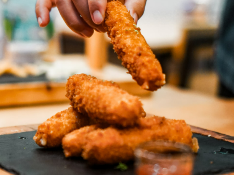 A serving of fried mozarella cheese sticks.